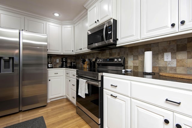 700 E Delmar St, Springfield, MO 65807 - kitchen featuring stainless steel appliances, white cabinetry, decorative backsplash, light wood-style floors, and recessed lighting