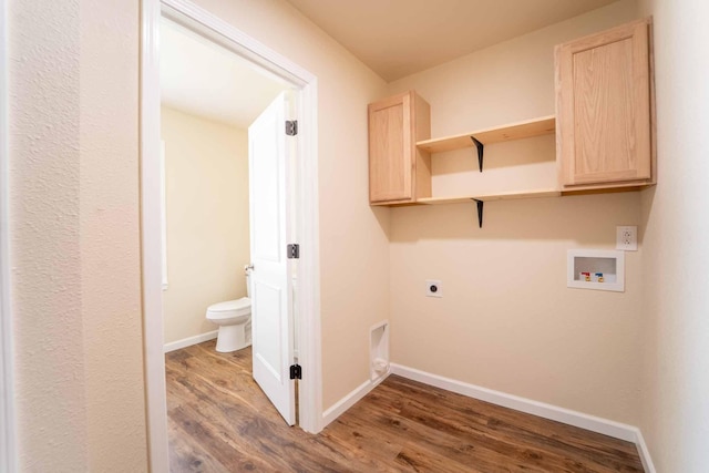 clothes washing area featuring hookup for a washing machine, hookup for an electric dryer, wood finished floors, and baseboards