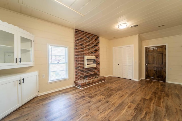 unfurnished living room with dark wood-style floors, a fireplace, heating unit, and baseboards