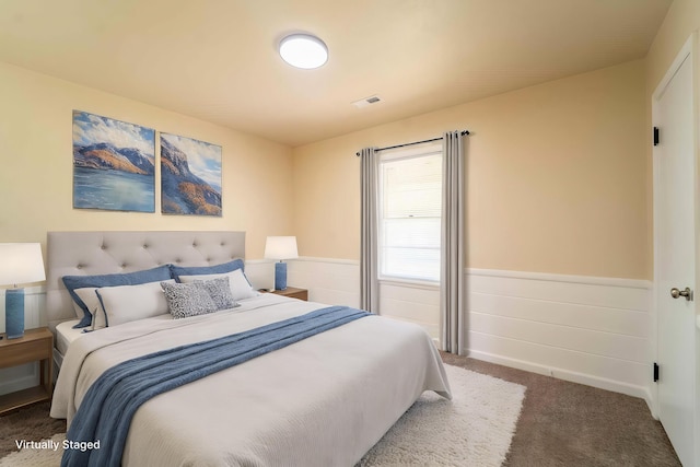 bedroom featuring carpet flooring and wainscoting