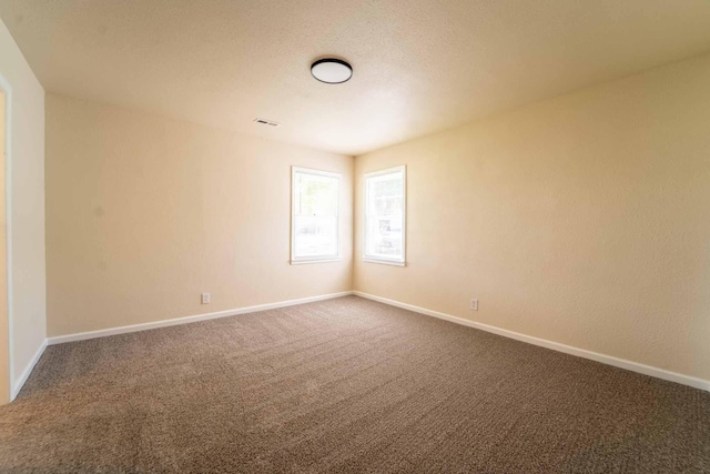 unfurnished room featuring carpet floors and baseboards