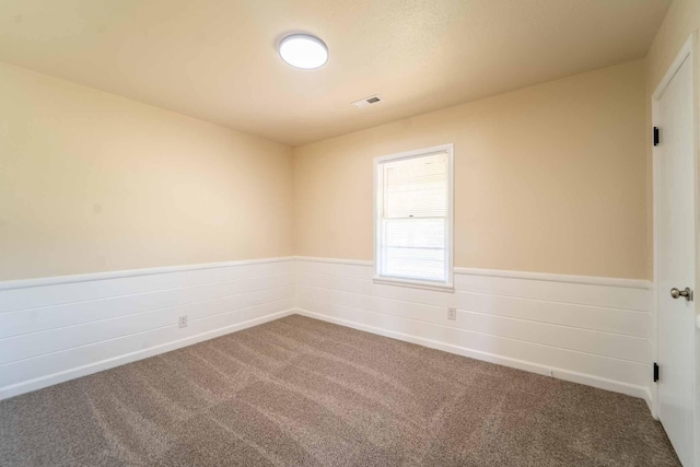 empty room with carpet and wainscoting