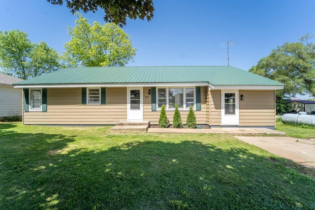 ranch-style house featuring a front yard and metal roof