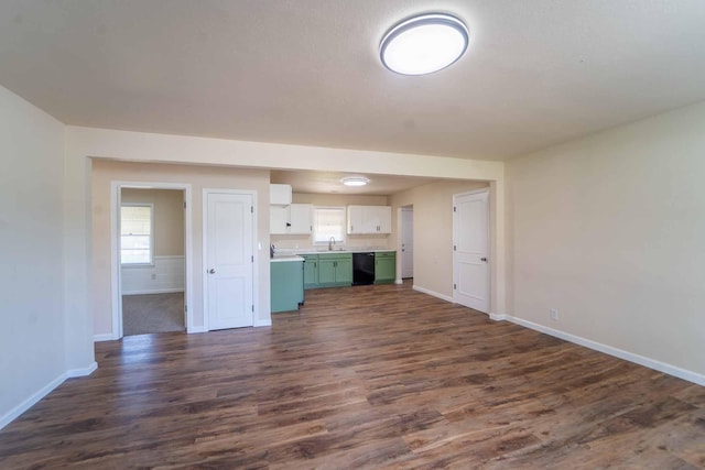 unfurnished living room with baseboards, dark wood-type flooring, and a sink