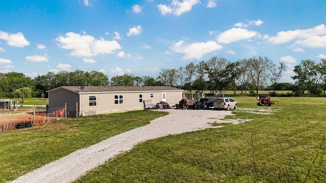 rear view of property featuring a yard and driveway