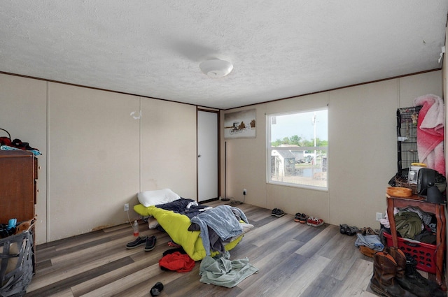 unfurnished bedroom featuring wood finished floors and a textured ceiling