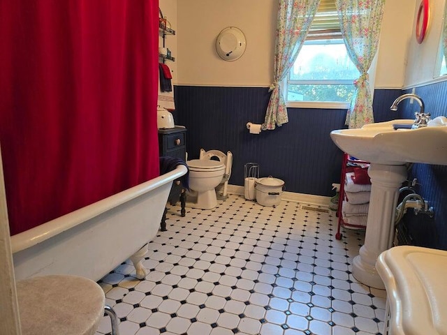 3590 County Road 7140, West Plains, MO 65775 - bathroom with a wainscoted wall, a bath, toilet, a sink, and baseboards