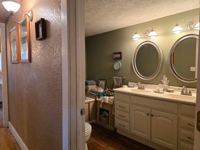 3590 County Road 7140, West Plains, MO 65775 - bathroom with wood finished floors, toilet, double vanity, and a textured ceiling