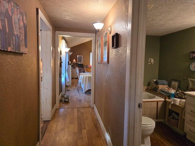 3590 County Road 7140, West Plains, MO 65775 - hall featuring wood finished floors, a textured ceiling, and a textured wall