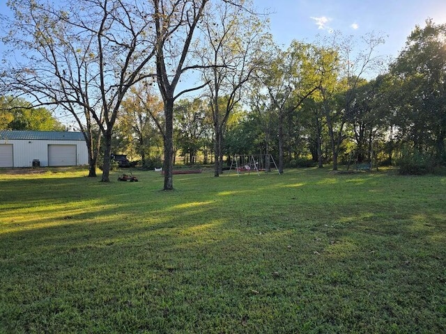 3590 County Road 7140, West Plains, MO 65775 - view of green lawn featuring a detached garage, a playground, and an outbuilding
