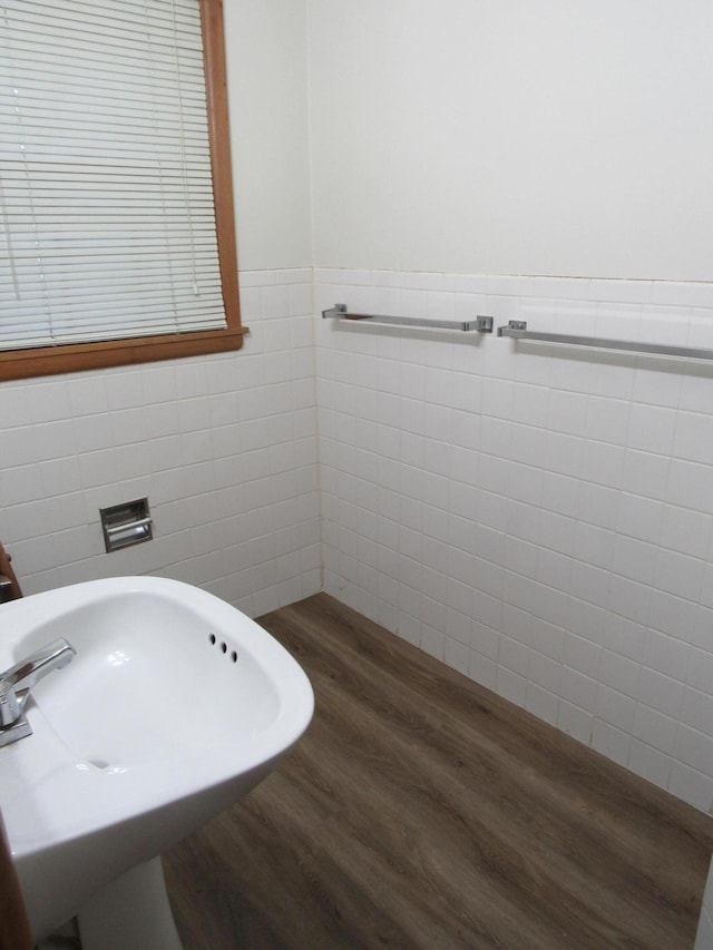 2124 S Kimbrough Ave, Springfield, MO 65807 - bathroom featuring tile walls, wood finished floors, a sink, and a wainscoted wall
