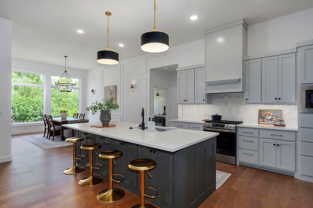 1698 N Marlowe Ave, Springfield, MO 65802 - kitchen with stainless steel gas range, a sink, light countertops, decorative backsplash, and a center island with sink