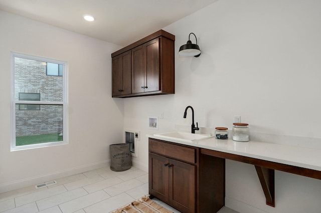 1698 N Marlowe Ave, Springfield, MO 65802 - laundry room with cabinet space, hookup for a washing machine, electric dryer hookup, baseboards, and light tile patterned floors