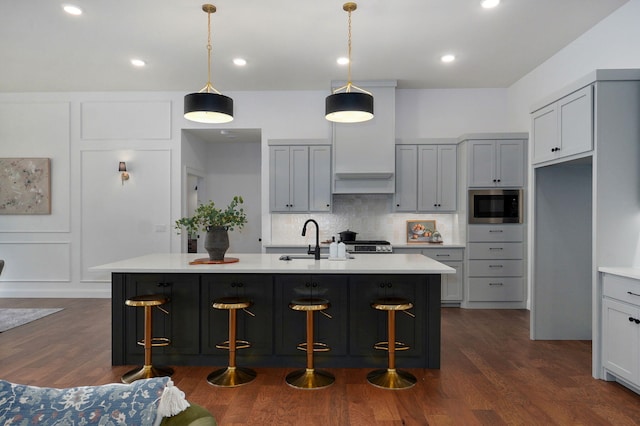 1698 N Marlowe Ave, Springfield, MO 65802 - kitchen with stainless steel microwave, a sink, light countertops, dark wood-type flooring, and tasteful backsplash