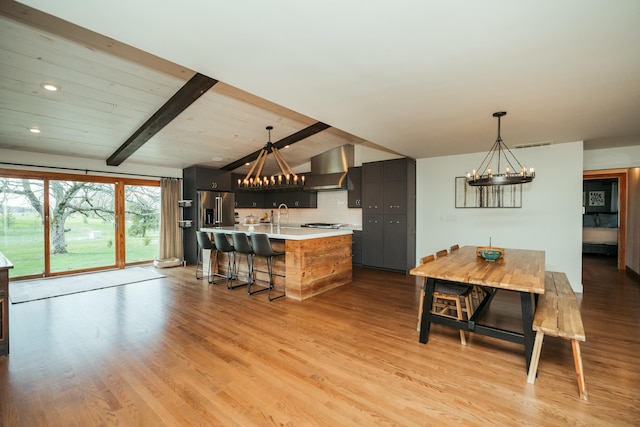 5724 E Mill St, Springfield, MO 65802 - kitchen featuring a chandelier, wall chimney range hood, light countertops, high quality fridge, and recessed lighting