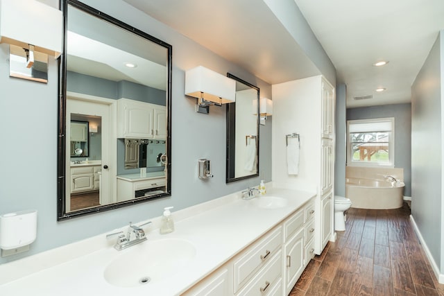 5724 E Mill St, Springfield, MO 65802 - full bath with a freestanding tub, double vanity, baseboards, wood finished floors, and recessed lighting