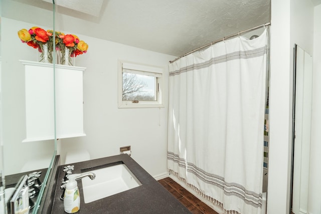 5724 E Mill St, Springfield, MO 65802 - full bath with a textured ceiling, a sink, wood finished floors, and a shower with shower curtain