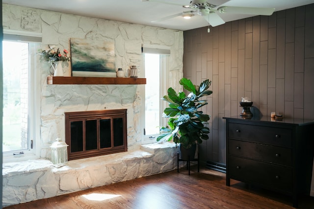 5724 E Mill St, Springfield, MO 65802 - living room with ceiling fan, wood finished floors, a stone fireplace, and wood walls