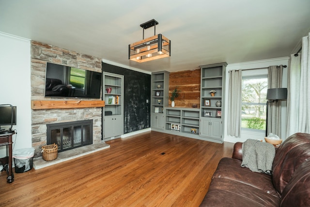 5724 E Mill St, Springfield, MO 65802 - living room with wood finished floors, a stone fireplace, and ornamental molding