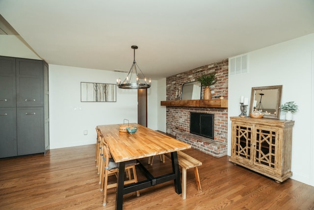 5724 E Mill St, Springfield, MO 65802 - dining room with wood finished floors, a fireplace, baseboards, and a chandelier