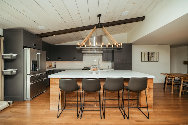5724 E Mill St, Springfield, MO 65802 - kitchen with high end fridge, light countertops, a chandelier, backsplash, and a breakfast bar area