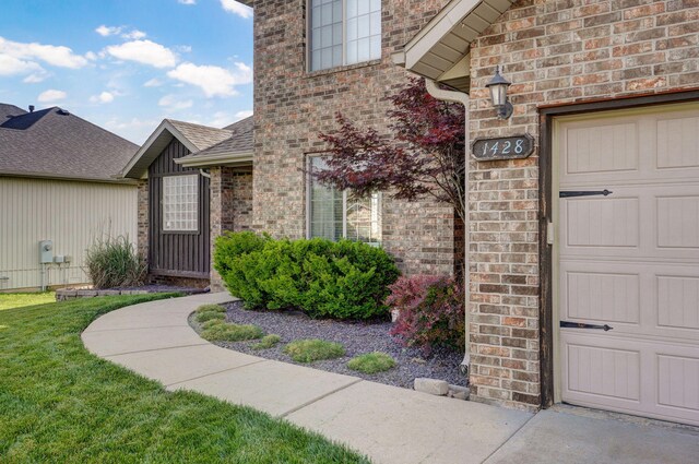 1428 S Appomattox Ave, Republic, MO 65738 - doorway to property with brick siding, a garage, a lawn, and a shingled roof