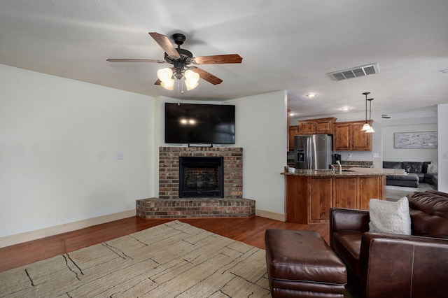 1428 S Appomattox Ave, Republic, MO 65738 - living room featuring wood finished floors, a ceiling fan, baseboards, and a brick fireplace