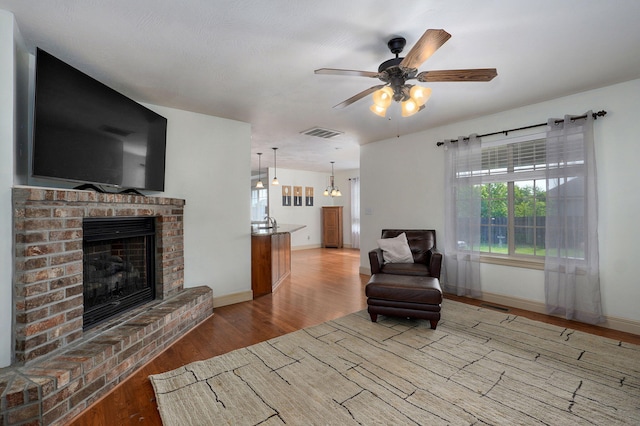 1428 S Appomattox Ave, Republic, MO 65738 - living area featuring a brick fireplace, wood finished floors, ceiling fan, and baseboards
