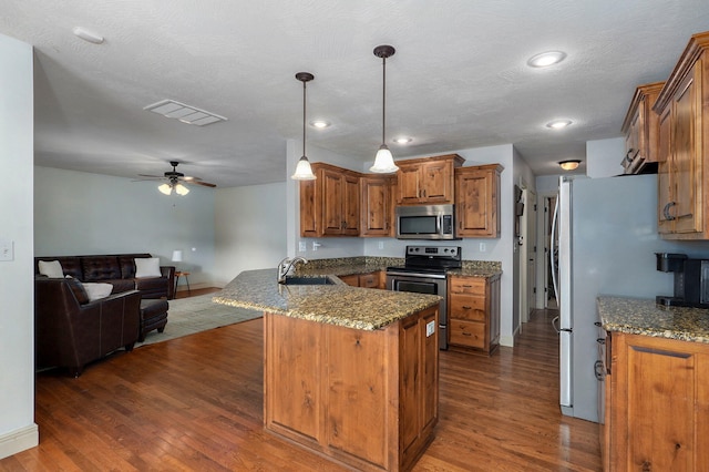 1428 S Appomattox Ave, Republic, MO 65738 - kitchen featuring stainless steel appliances, a sink, brown cabinetry, a peninsula, and dark wood-style flooring