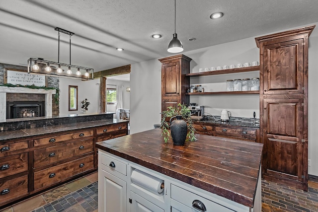 16326 Lawrence Unit 1232, Marionville, MO 65705 - kitchen with wood counters, hanging light fixtures, open shelves, a fireplace, and a textured ceiling