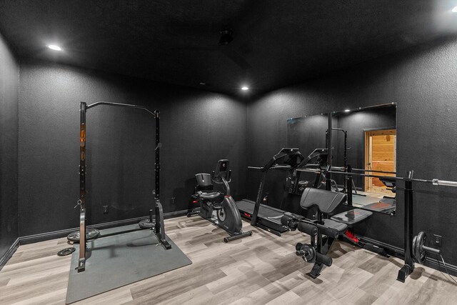 16326 Lawrence Unit 1232, Marionville, MO 65705 - exercise area featuring wood finished floors, a textured wall, and baseboards