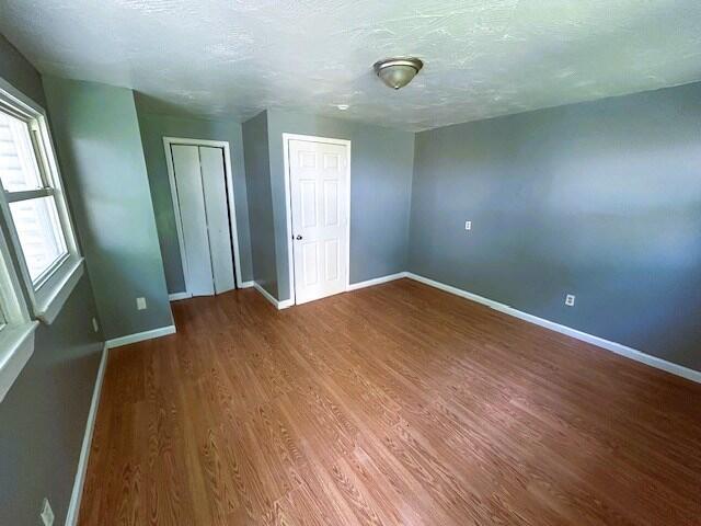 2238 N Rogers Ave, Springfield, MO 65803 - unfurnished room featuring baseboards, wood finished floors, and a textured ceiling