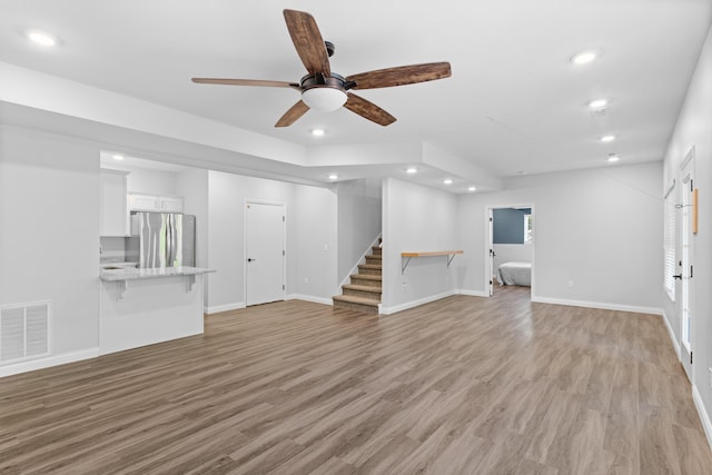 5404 S Clifton Ave, Springfield, MO 65810 - unfurnished living room featuring ceiling fan, stairs, light wood-type flooring, recessed lighting, and baseboards