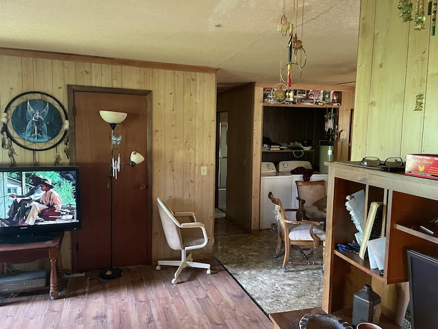 dining area featuring separate washer and dryer, wood walls, wood finished floors, a textured ceiling, and water heater