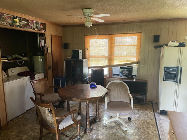 dining area with washer and dryer, a ceiling fan, a textured ceiling, wooden walls, and water heater