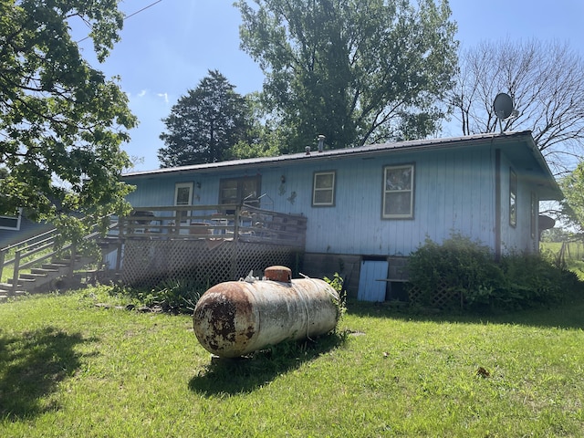 rear view of house with a deck and a yard