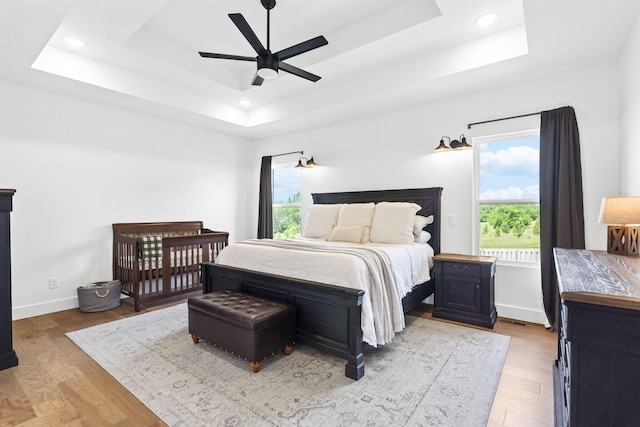 4531 E Hidden Oak St, Springfield, MO 65802 - bedroom featuring a tray ceiling, multiple windows, light wood finished floors, and recessed lighting