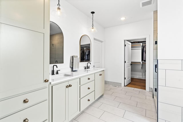4531 E Hidden Oak St, Springfield, MO 65802 - full bathroom with a spacious closet, tiled shower, double vanity, recessed lighting, and baseboards
