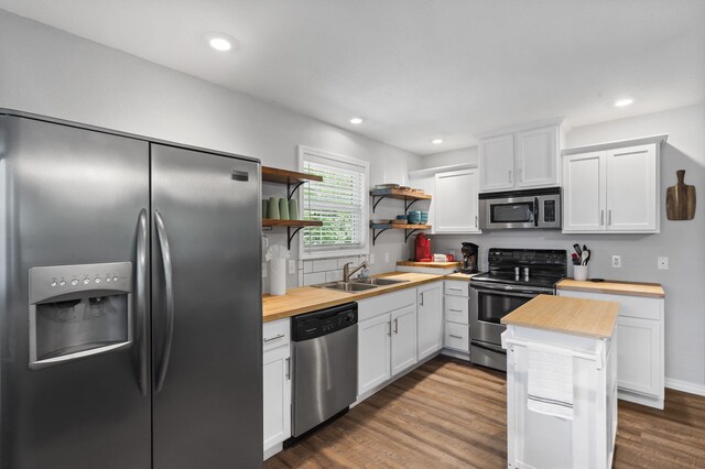 17 Montague Ln, Kimberling City, MO 65686 - kitchen featuring stainless steel appliances, butcher block countertops, a sink, open shelves, and dark wood-type flooring