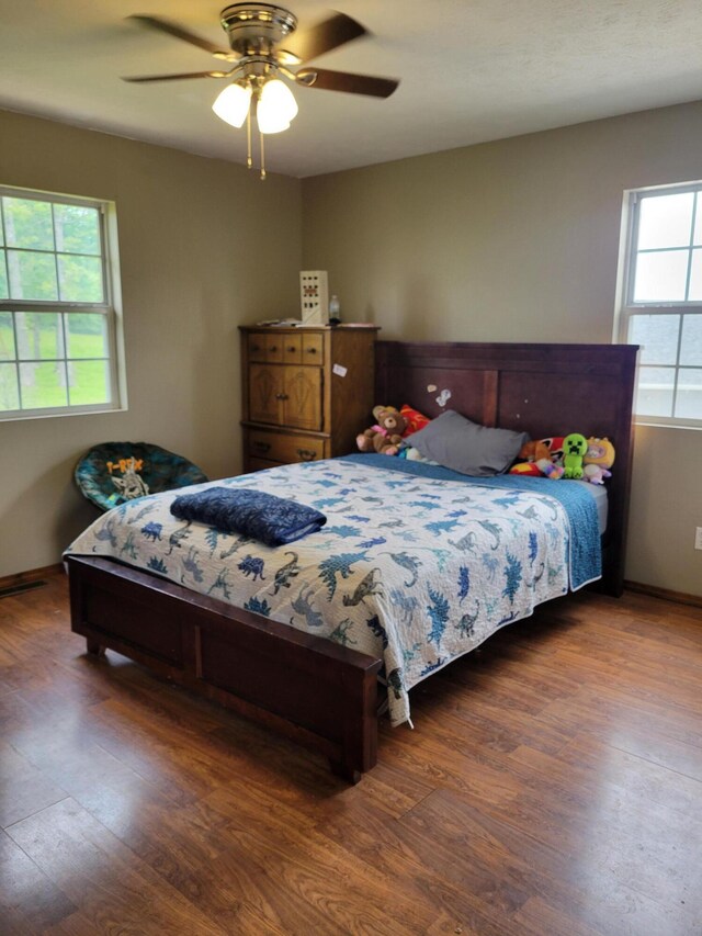 1995 Corder Pass Rd, Mansfield, MO 65704 - bedroom featuring wood finished floors, multiple windows, ceiling fan, and baseboards