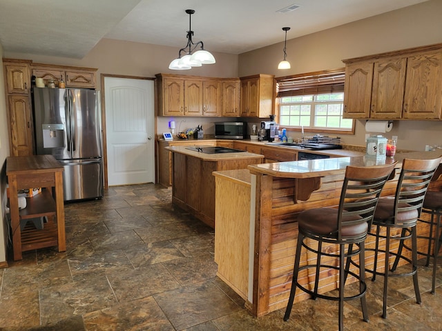 1995 Corder Pass Rd, Mansfield, MO 65704 - kitchen with appliances with stainless steel finishes, stone tile floors, a kitchen island, light countertops, and a peninsula