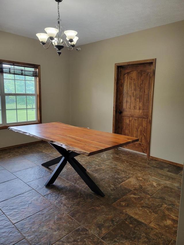 1995 Corder Pass Rd, Mansfield, MO 65704 - unfurnished dining area featuring stone tile flooring, a chandelier, and baseboards