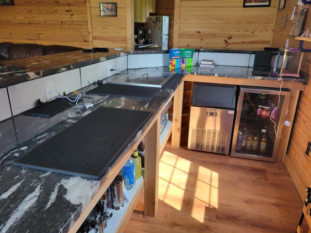 1995 Corder Pass Rd, Mansfield, MO 65704 - kitchen featuring wood walls, wood finished floors, beverage cooler, and freestanding refrigerator