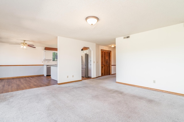 150 Sunken Forest Dr Unit 190, Forsyth, MO 65653 - unfurnished living room featuring light colored carpet, a ceiling fan, arched walkways, baseboards, and a wainscoted wall