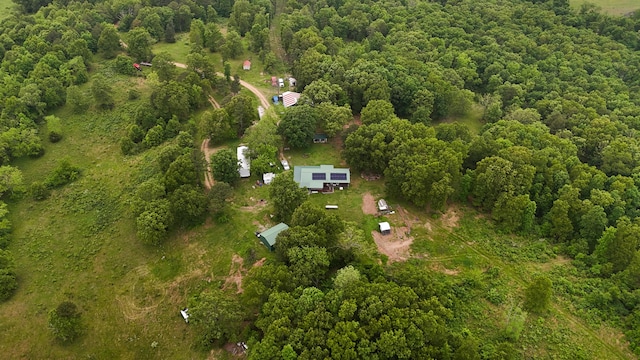 aerial view of property and surrounding area featuring a heavily wooded area