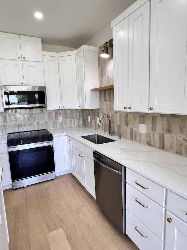 2077 N Sun Valley Dr, Springfield, MO 65802 - kitchen featuring appliances with stainless steel finishes, a sink, open shelves, white cabinets, and tasteful backsplash