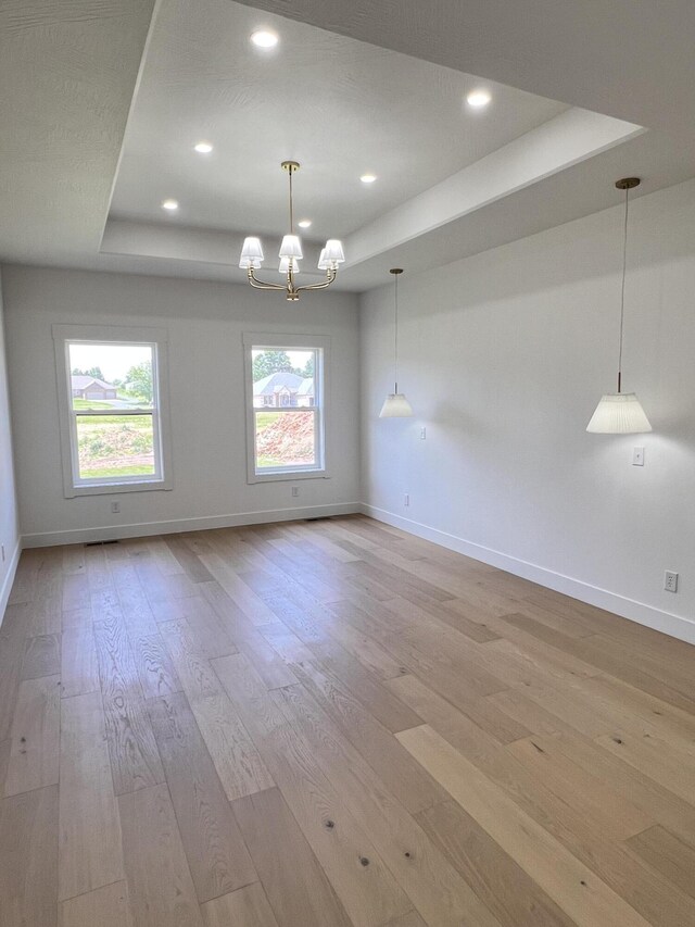 2077 N Sun Valley Dr, Springfield, MO 65802 - empty room with a tray ceiling, baseboards, light wood finished floors, a chandelier, and recessed lighting