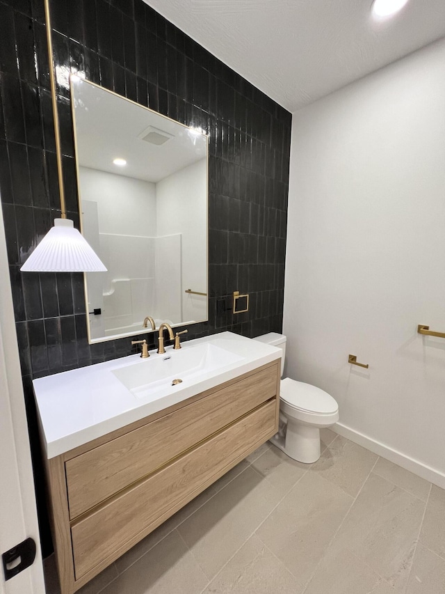 2077 N Sun Valley Dr, Springfield, MO 65802 - bathroom featuring tile walls, vanity, toilet, baseboards, and recessed lighting