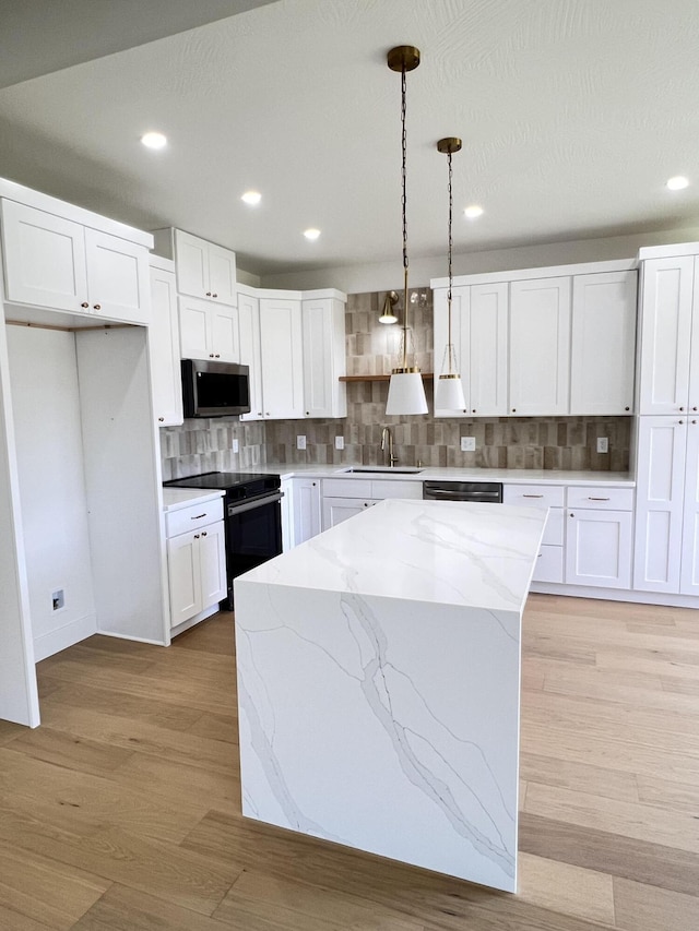 2077 N Sun Valley Dr, Springfield, MO 65802 - kitchen featuring electric range, stainless steel microwave, a sink, decorative light fixtures, and a center island