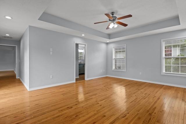 805 S Benson Pl, Nixa, MO 65714 - unfurnished room featuring a tray ceiling, light wood finished floors, healthy amount of natural light, ceiling fan, and recessed lighting